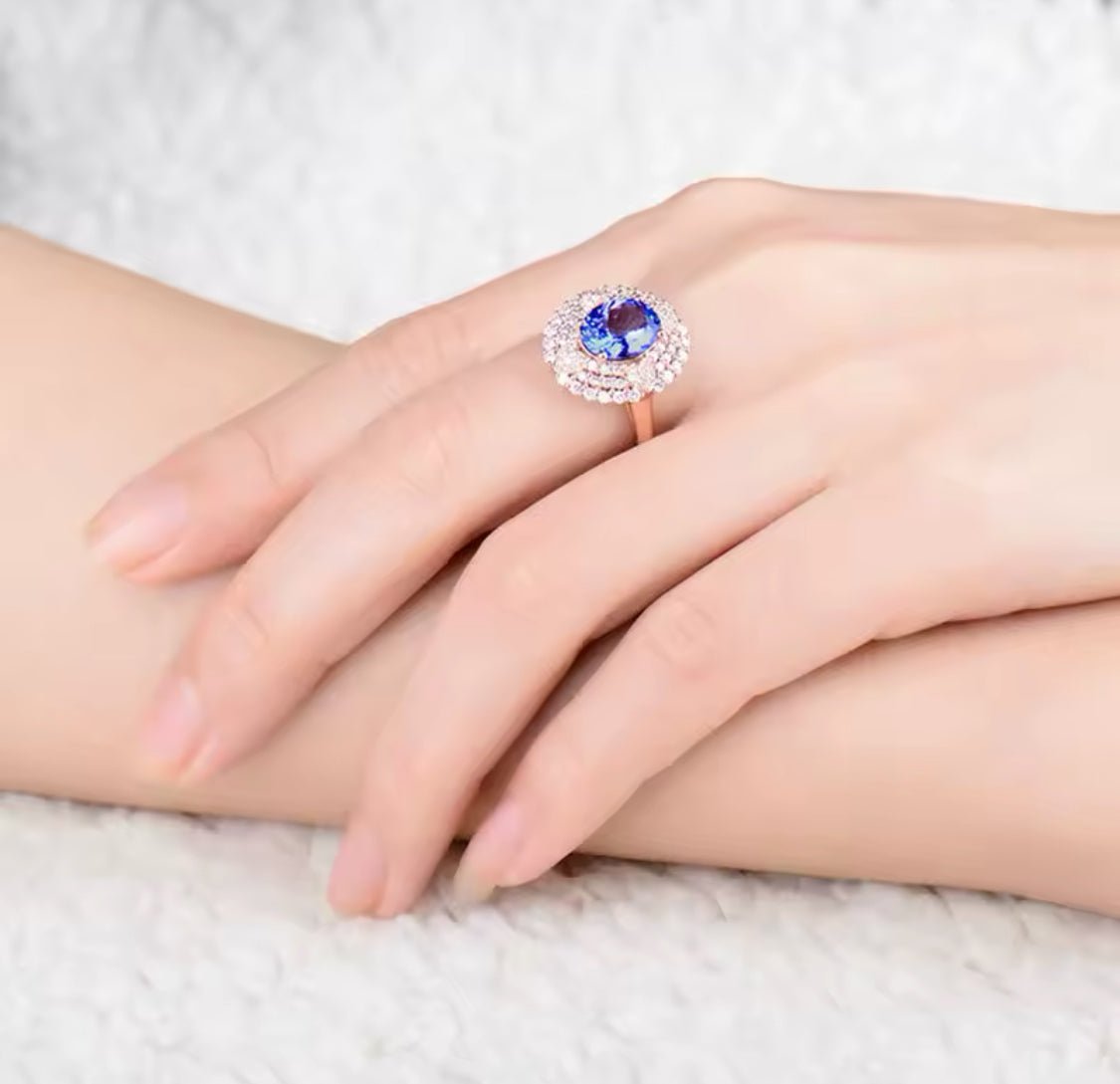Natural oval tanzanite and diamond ring in 18K rose gold worn on hand