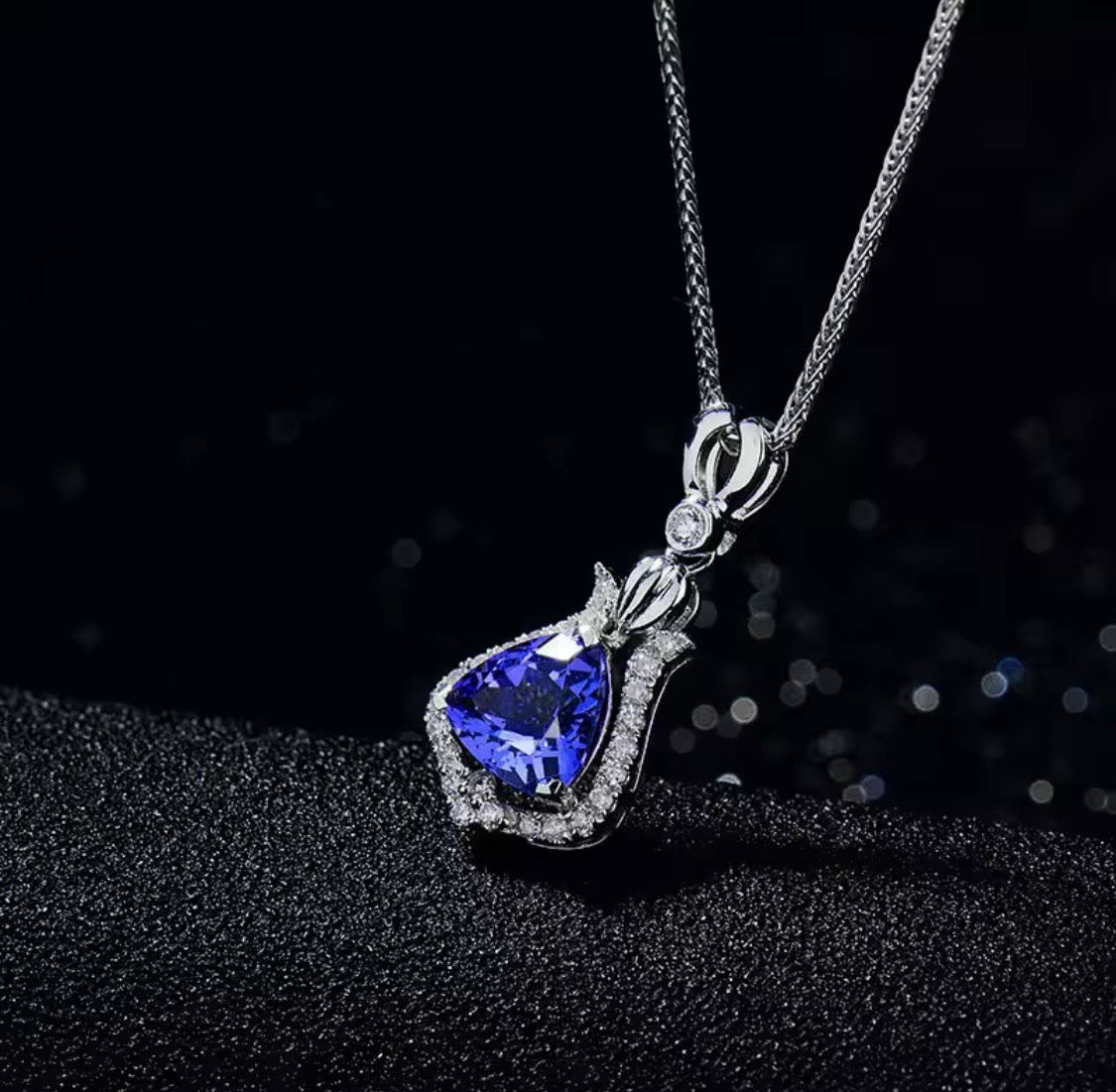 Natural trillion-cut tanzanite and diamond pendant in 18K white gold lifestyle view