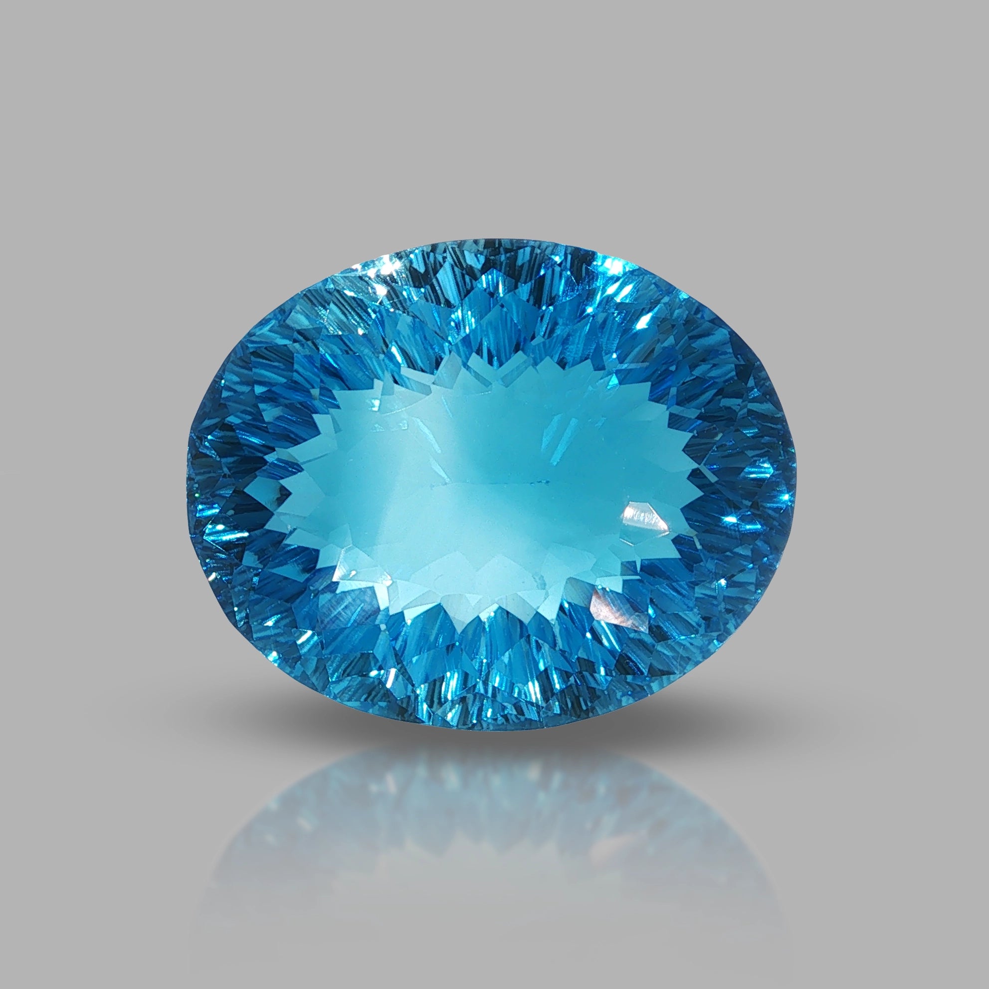 Natural Swiss Blue Topaz, 63.27 carats, oval concave cut, eye-clean clarity, vivid Swiss blue color, transparent gemstone