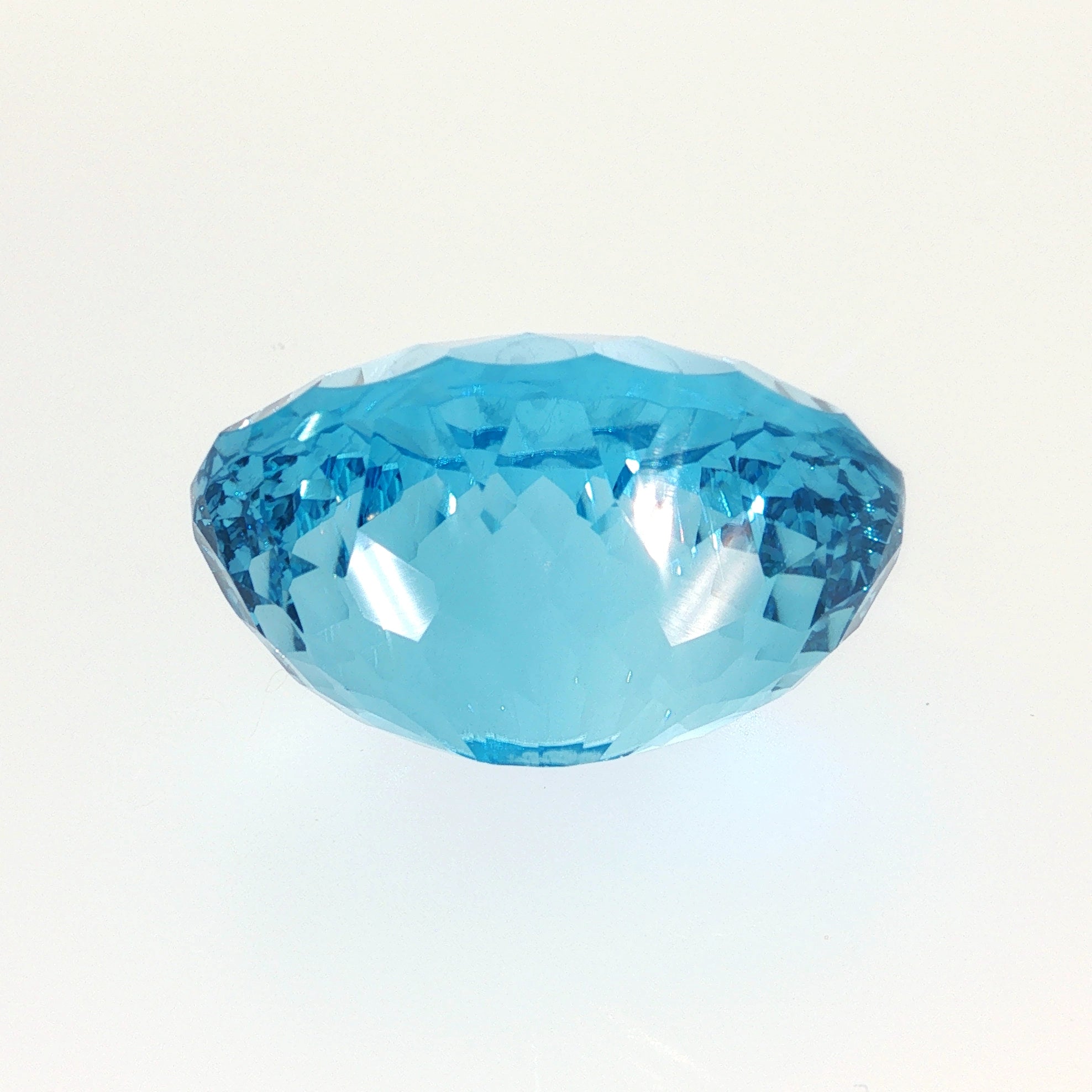 Natural Swiss Blue Topaz, 63.27 carats, oval concave cut, eye-clean clarity, vivid Swiss blue color, transparent gemstone