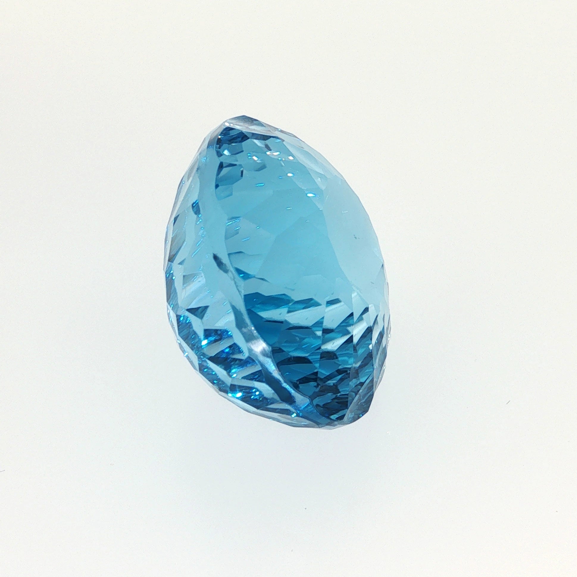 Natural Swiss Blue Topaz, 63.27 carats, oval concave cut, eye-clean clarity, vivid Swiss blue color, transparent gemstone