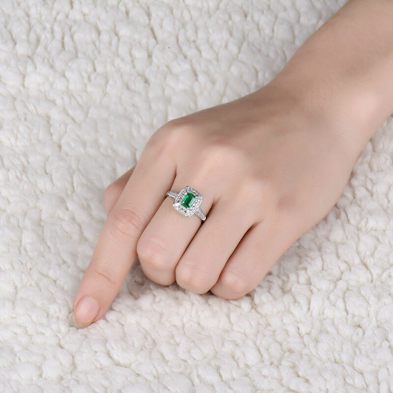 Natural emerald and diamond ring in 18K white gold worn on hand