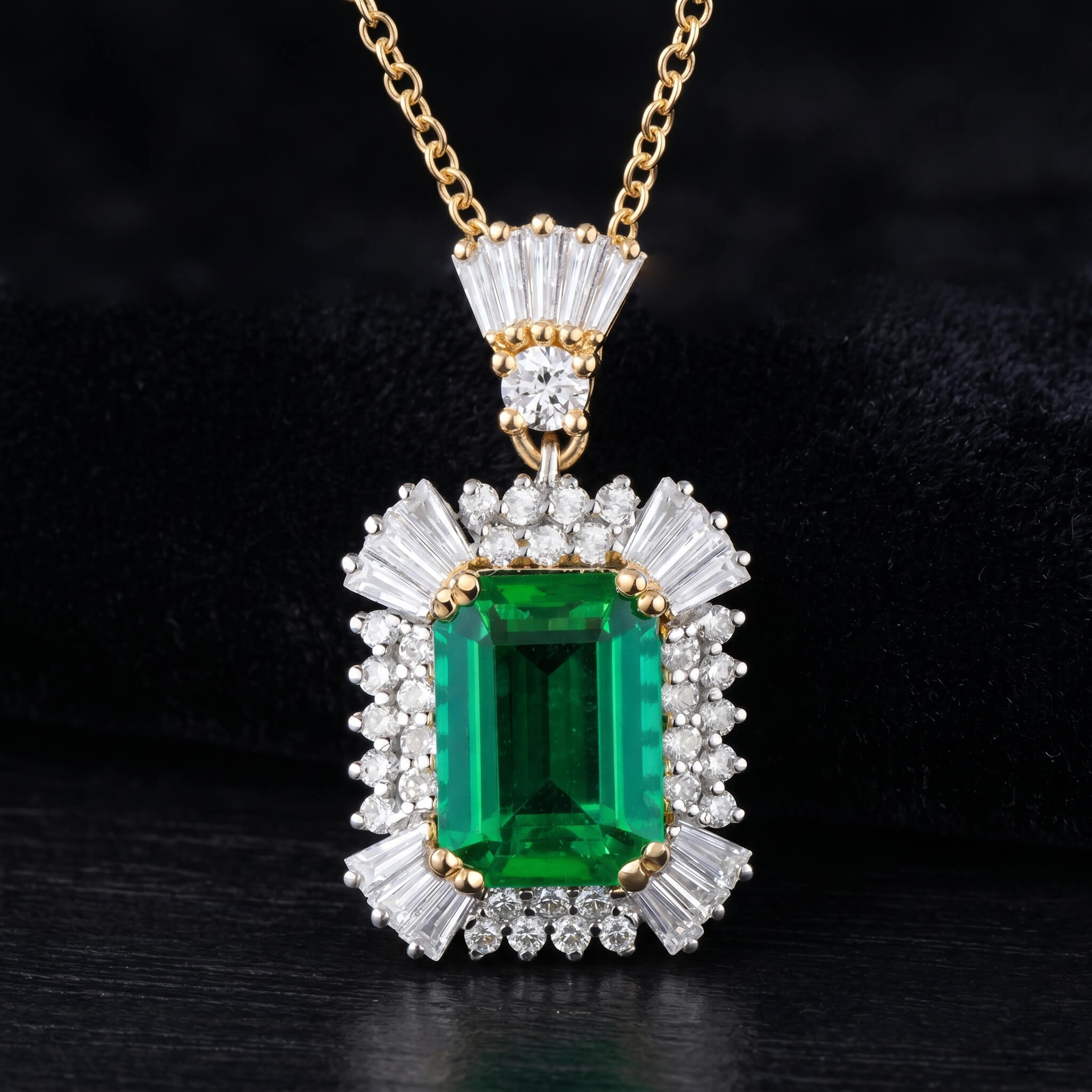 Natural green emerald pendant with diamonds in yellow gold on dark background