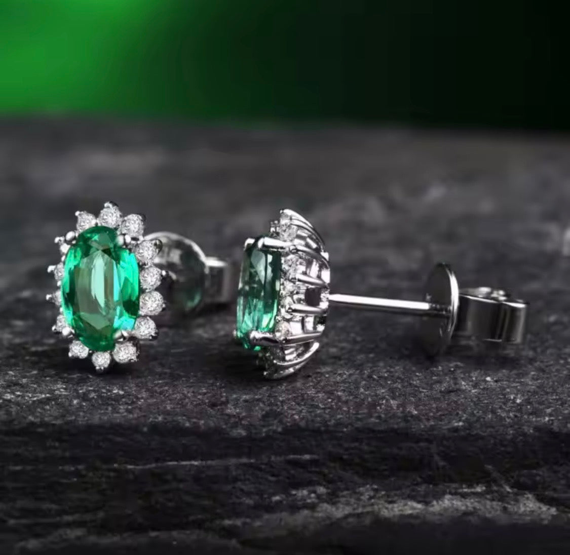 18K gold emerald stud earrings with oval 4x6mm gemstones and diamond halo design