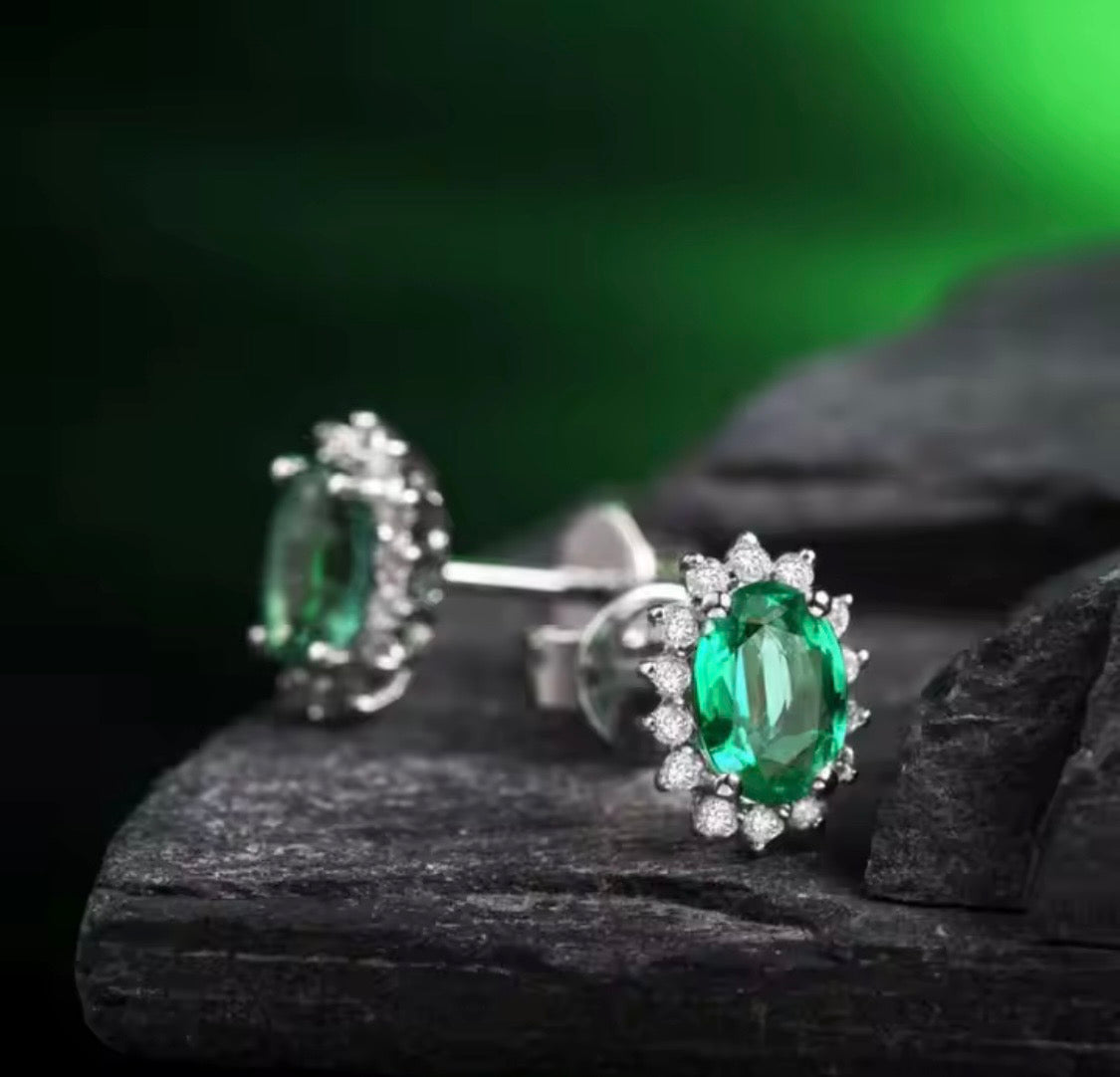 18K gold emerald stud earrings with oval 4x6mm gemstones and diamond halo design