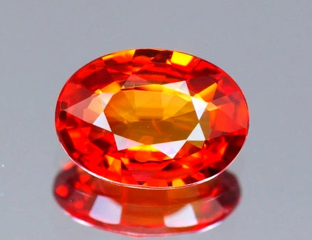 Natural orange sapphire gemstone, 0.87 carats, oval cut, fire orange red color, VVS clarity, Madagascar origin, beryllium treated, seller's certificate