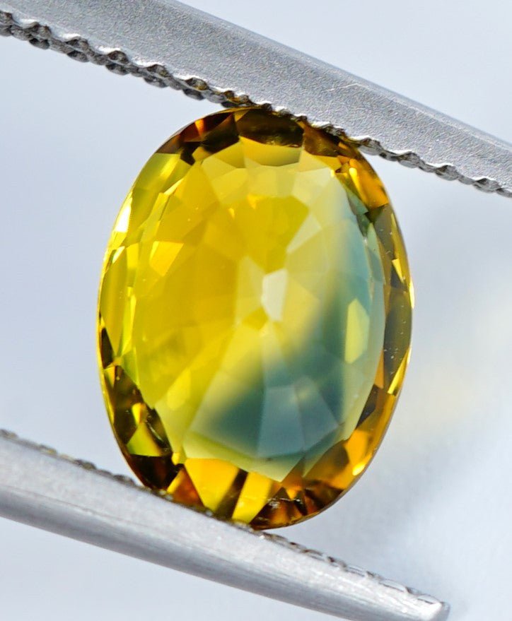 Natural 2.06 ct green yellow sapphire from Australia in tweezers back side