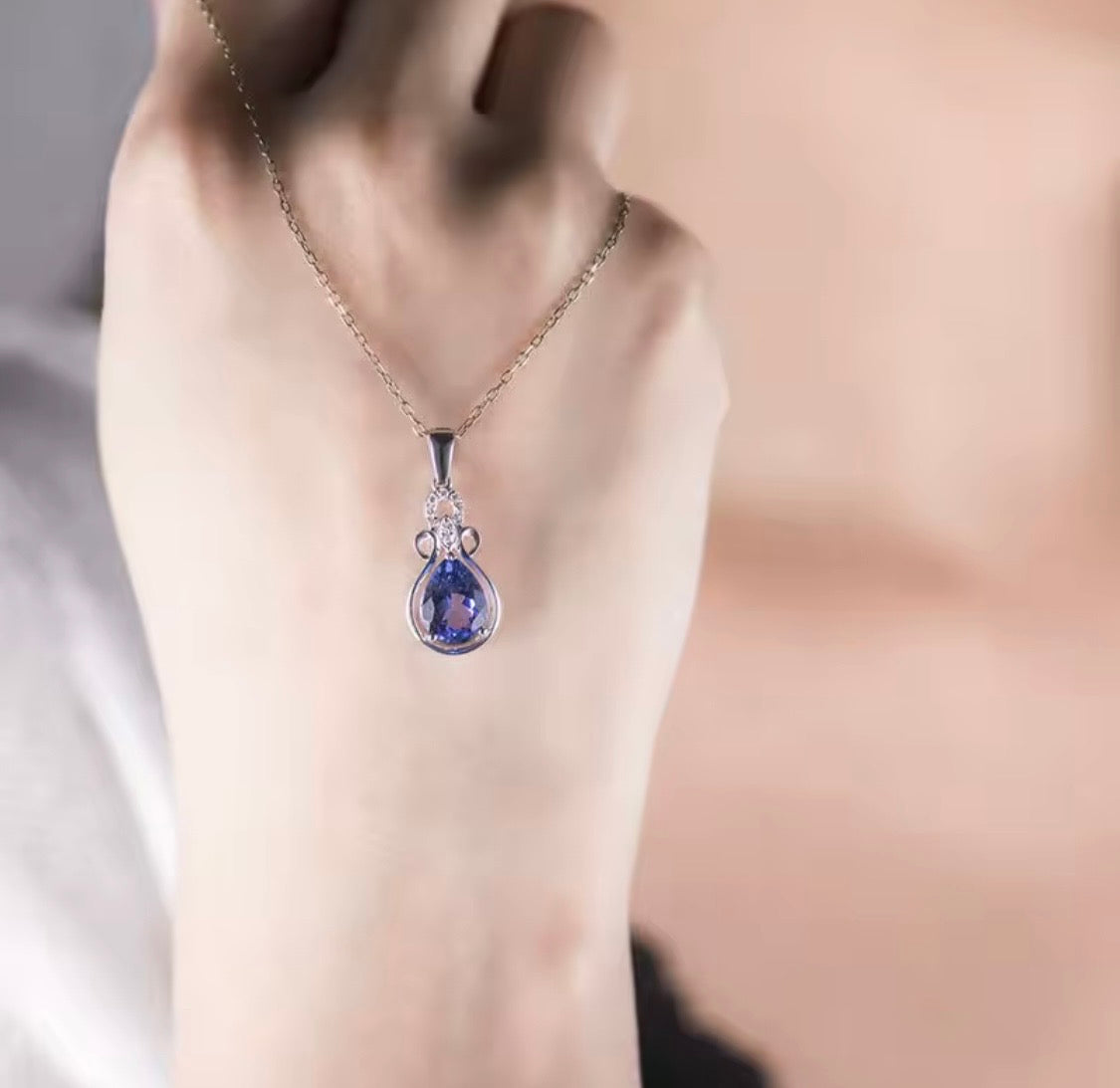 1.85 ct natural pear tanzanite and diamond pendant in 14K white gold shown on hand