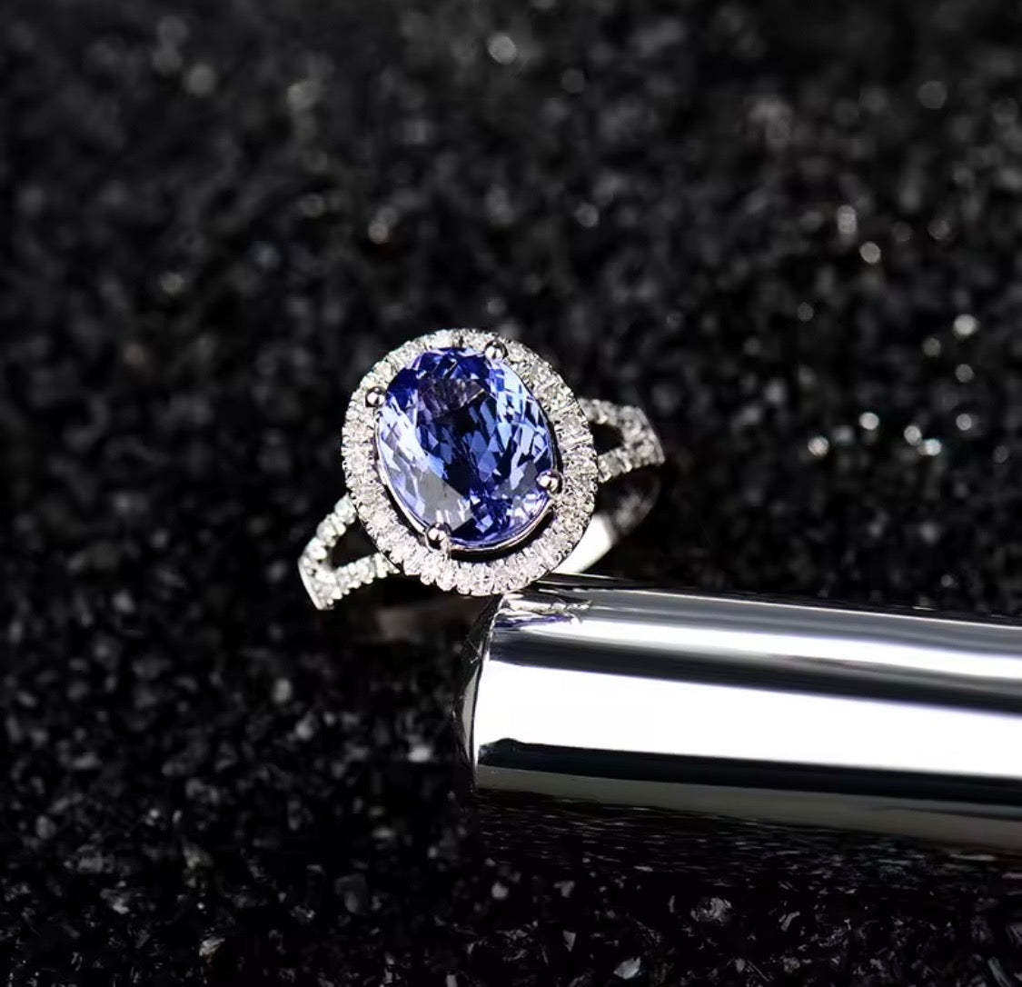 Close-up of natural oval tanzanite with diamond halo in 14K white gold