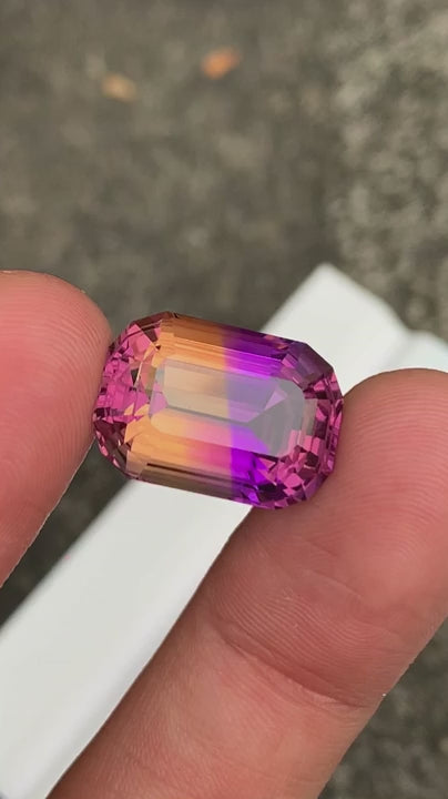 Natural bicolor ametrine in fancy cushion cut holded in hand