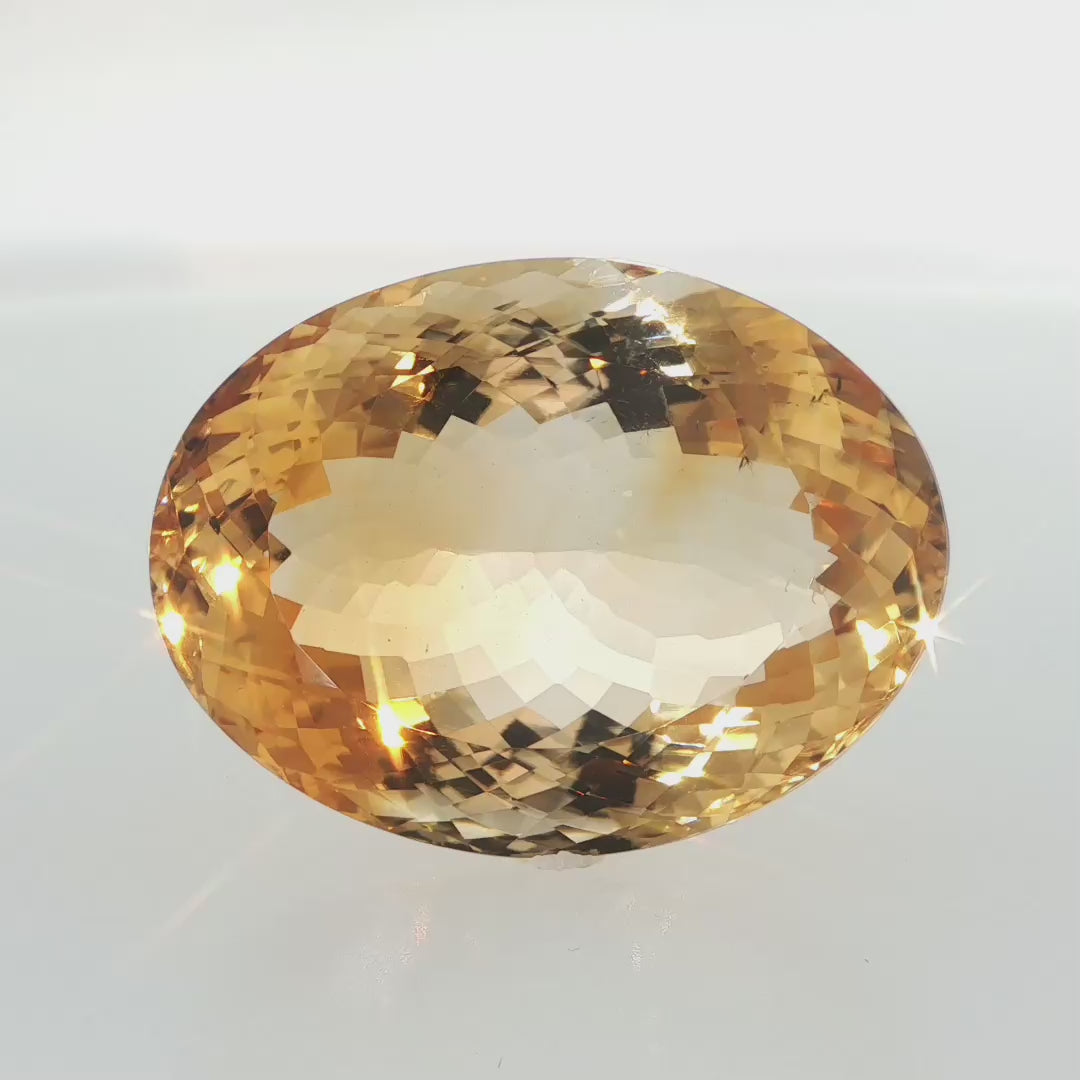 Natural citrine, 106.05 carats, oval cut, clarity: slightly included, golden-yellow color, measuring 36.85 × 27.62 × 17.94 mm