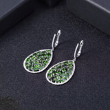 Silver earrings with natural chrome diopside on dark background