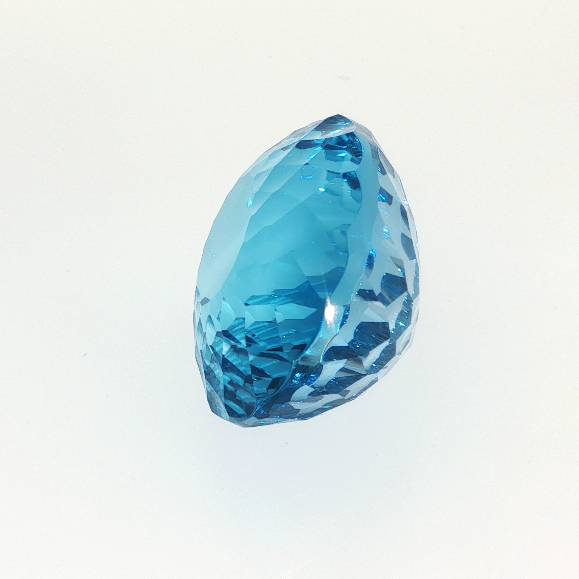 Natural Swiss Blue Topaz, 63.27 carats, oval concave cut, eye-clean clarity, vivid Swiss blue color, transparent gemstone