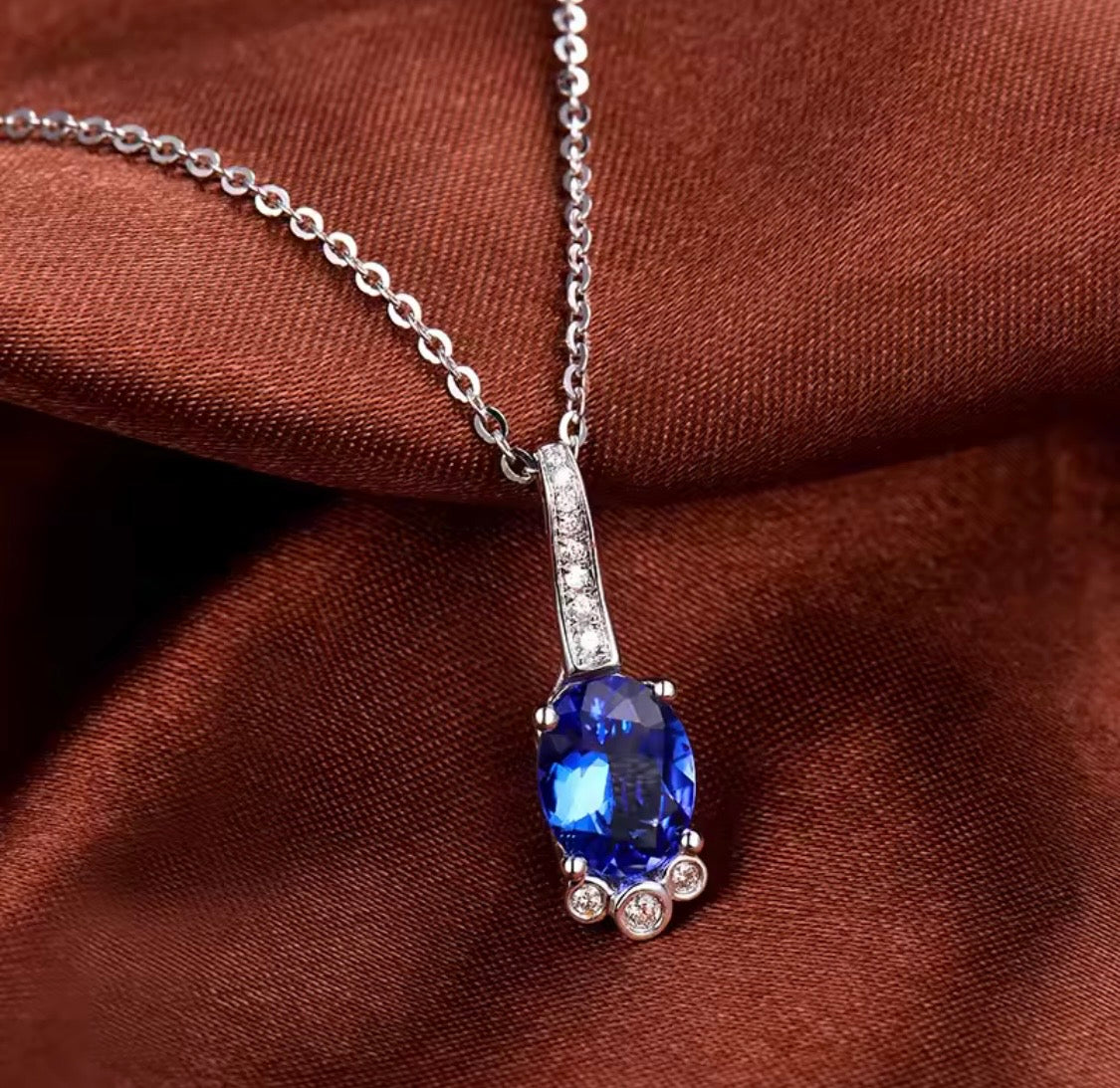 18K gold tanzanite pendant with oval 7x9mm gemstone and diamond drop design